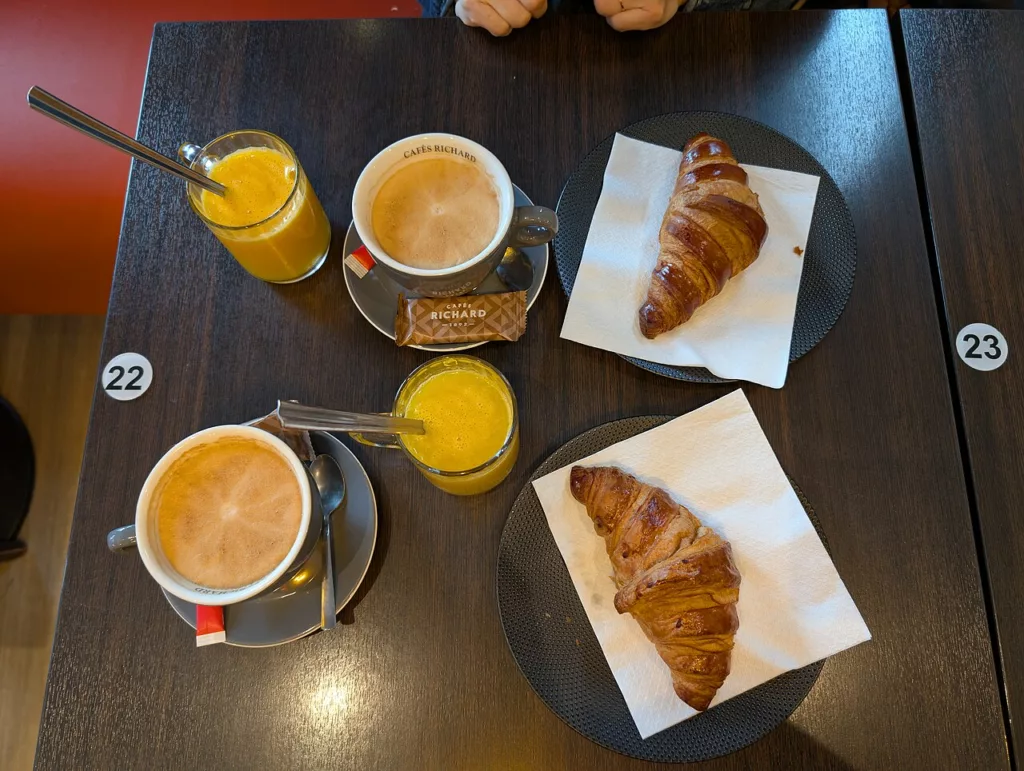 Items on the table: 2 glasses of orange juice 2 cups of coffee 2 croissants