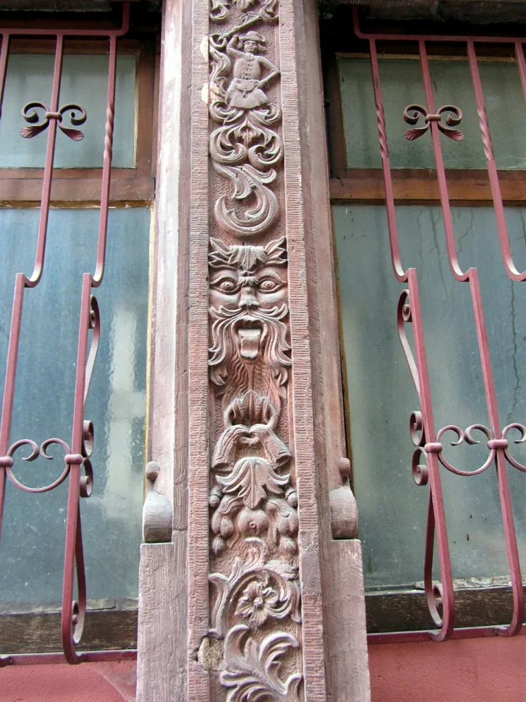 La deuxième fenêtre à gauche de la porte s'inscrit entre deux montants (?)Les reliefs puisent au répertoire de la Rennaissance : têtes grotesques, fruits, feuil